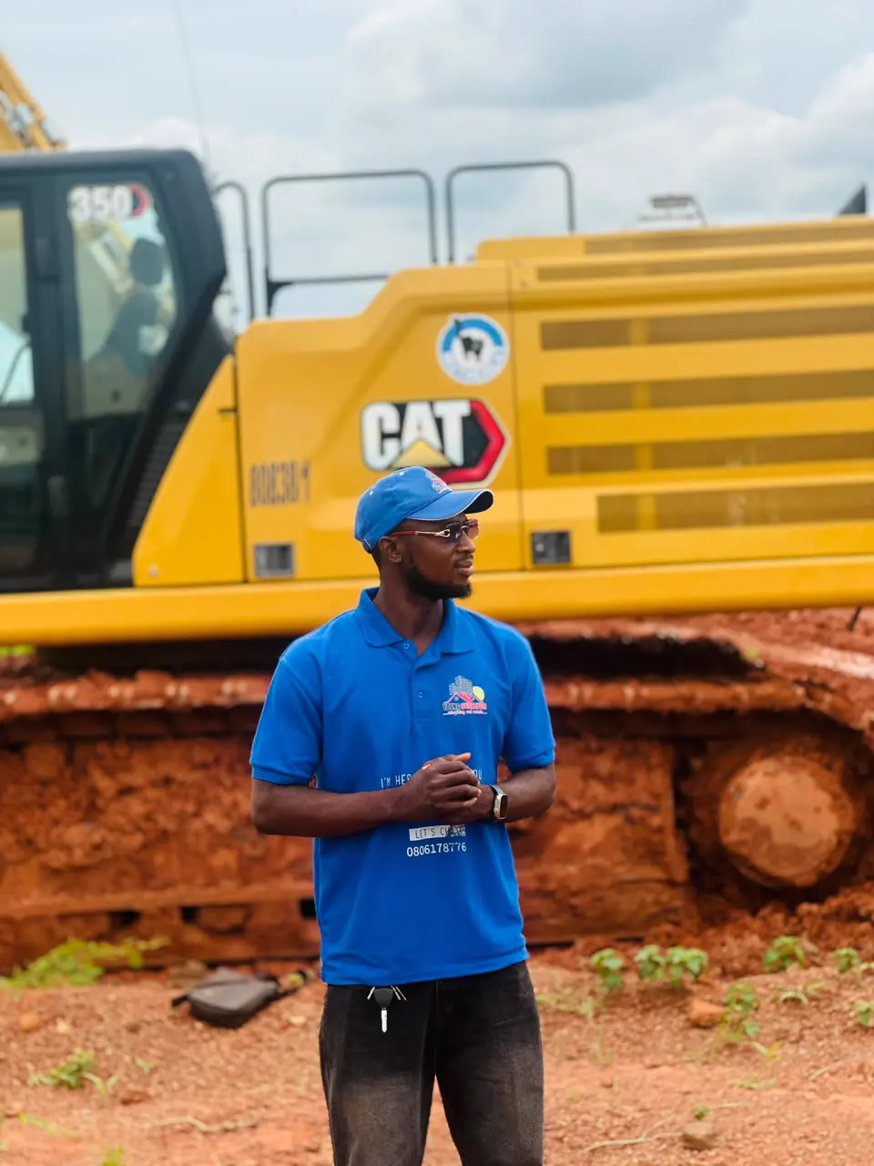 A Young Surveyor & Properties team member on a development site beside an excavator